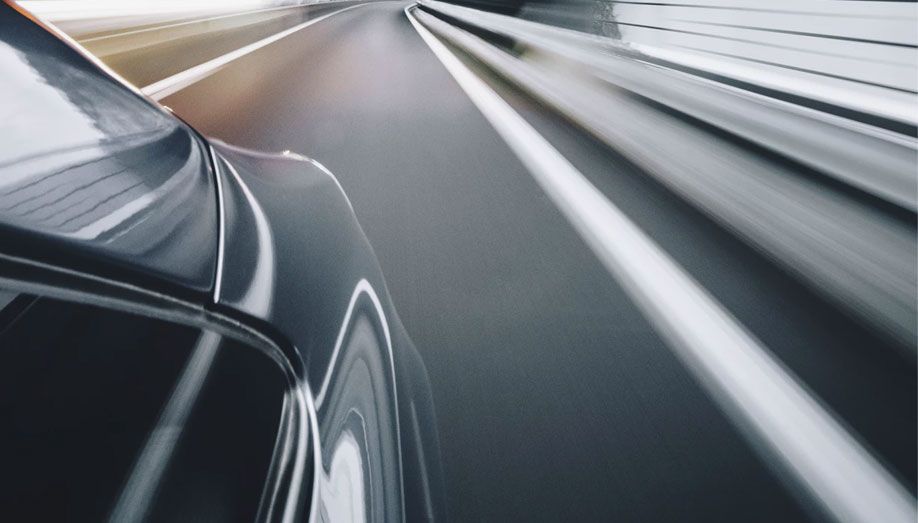 Side view of a car driving down the road