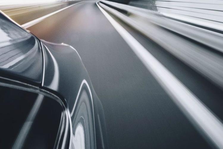 Side view of a car driving down the road